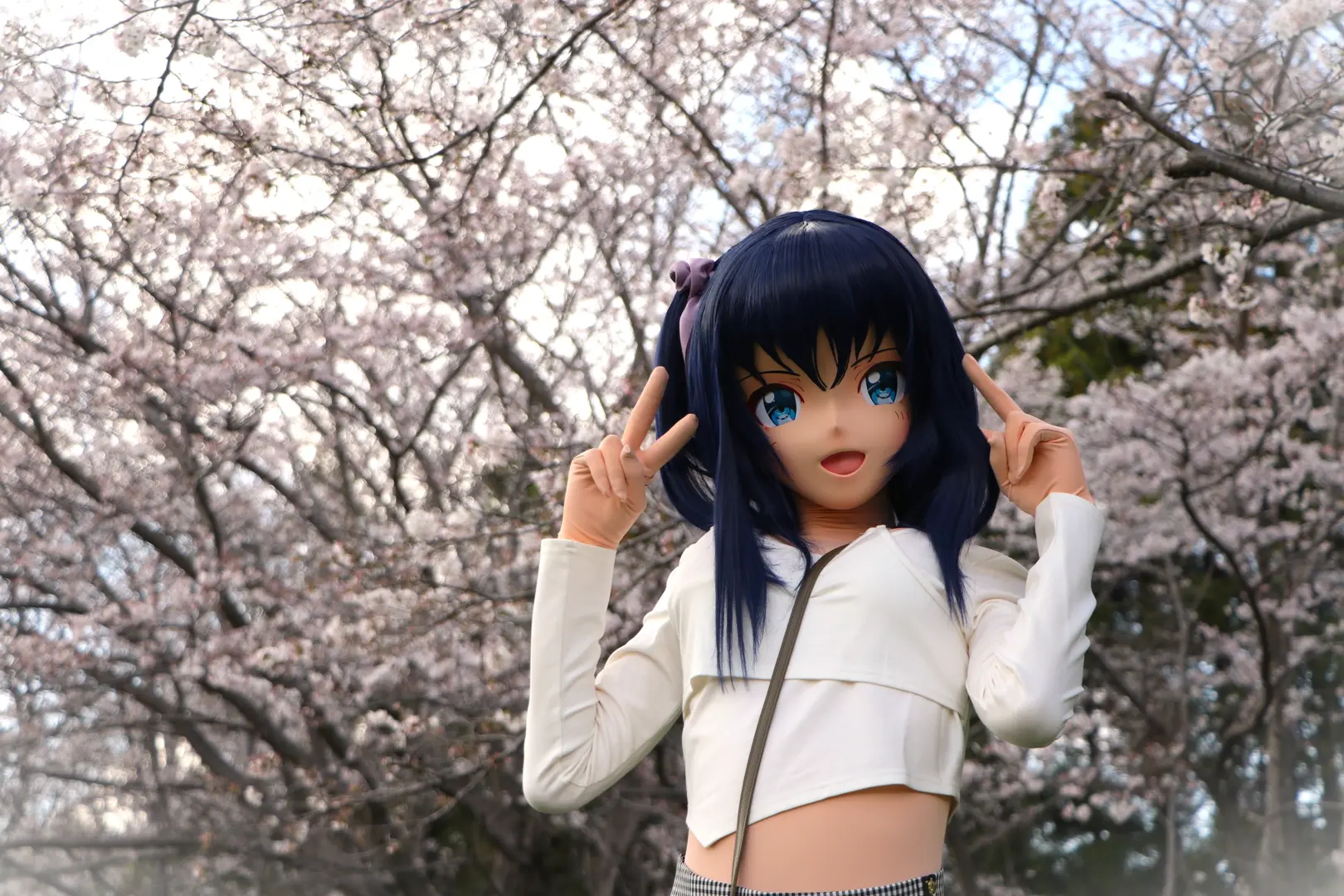 桜並木の前で両手をピースするOsumi Akari